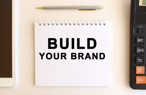 Блокнот Текстом Build Your Brand Білому Тлі Біля Калькулятора Планшета — стокове фото