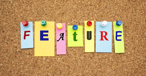 Multicolor notes with letters pinned on a cork notice board. Work space.