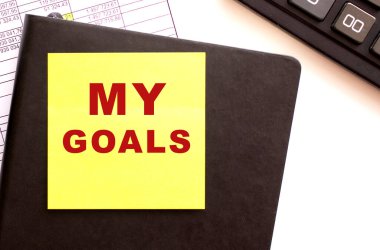 Üzerinde yazı olan siyah deri bir defter..