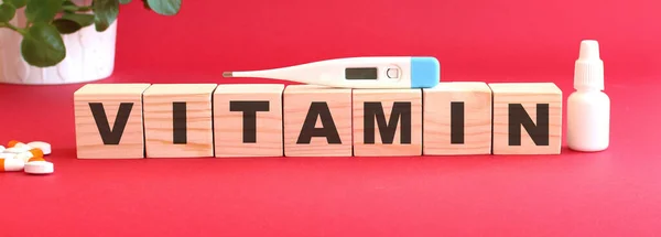Słowo Vitamin Jest Wykonane Drewnianych Kostek Czerwonym Tle Lekami Medycznymi — Zdjęcie stockowe