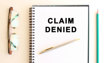 Beyaz arkaplanda, gözlük ve kalemin yanında metin olan not defteri.