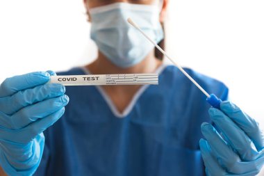 Doktor ya da hemşire COVID-19 bez toplama kiti ile nitril eldiven takıyor.