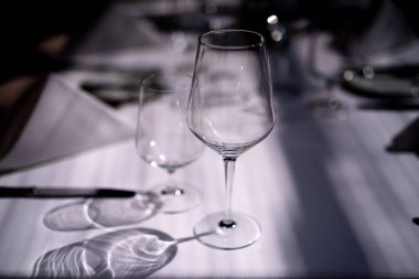 Masa beyaz bir masa örtüsüyle kaplı, ürünler var, ışık camdan güzelce düşüyor, fotoğraf parlak.