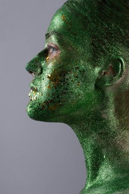 Yeşil parıltılardan, moda portresinden, parlayan yeşil tenli bir kızın yakın plan portresi.