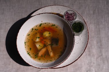 Bir kase çorba kumaş bir masa örtüsünün üzerinde duruyor.