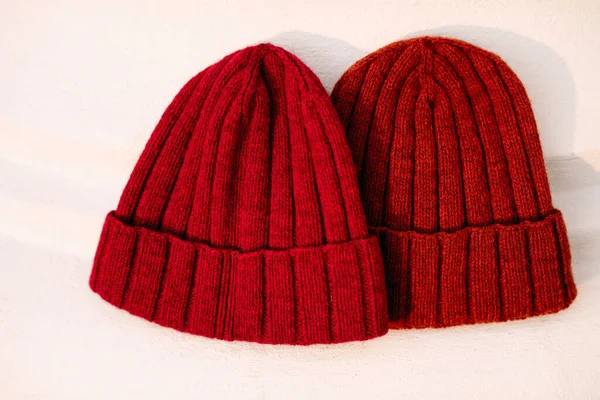 on a white background are two red knitted hats, a striped hat pattern, hats knitted