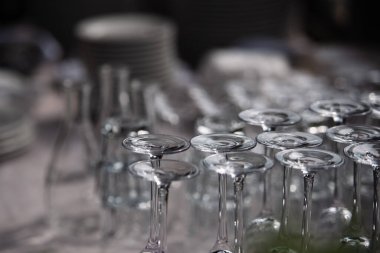 Ters çevrilmiş bardaklar masanın üzerinde duruyor, cam parlıyor.