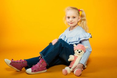 Bir kızın portresini yakından çek, ellerini katlamış ve yana bakıyor. Gülümse ve yüzünde bir şapkayla neşe