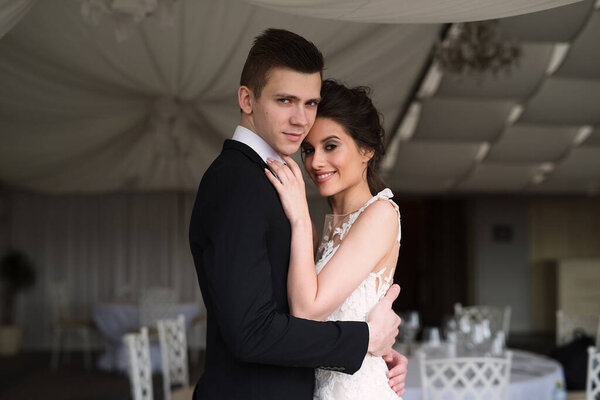 the groom and the bride kiss in the city, the guy hugs the girl, a wedding in Prague