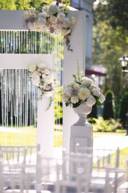 Çiçek vazosuyla beyaz bir düğün kemeri dekorasyonu, şenlikli dekor, arka plan tarzı bulanıklaştırdı