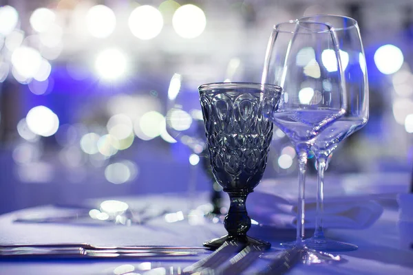 青い背景にワイングラスが立ち美しいワイングラスが光から輝きガラスにまぶしさを与え — ストック写真