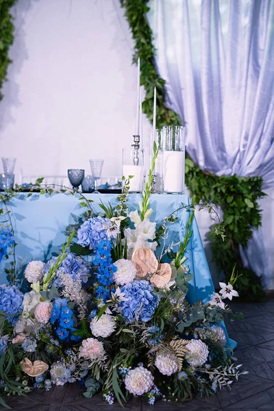 Arreglo Floral Una Mesa Con Mantel Azul Velas Blancas Platos — Foto de Stock