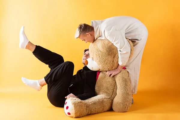 in love gay couple playing with  toy bear