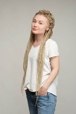 Saçları örgülü, elleri ceplerinde genç ve çekici bir hippi kız.