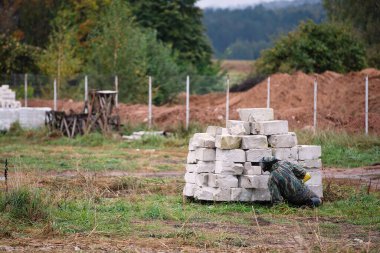 Koruyucu üniformalı adam paintball oynar, çitlerin arkasına saklanır.,