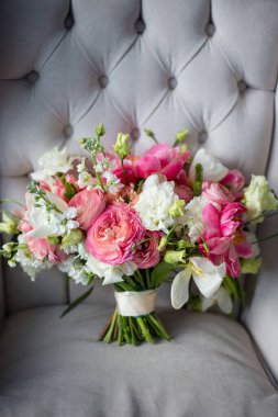 Hassas pembe ve beyaz çiçek buketi, yakın plan çiçek, seçici odak, buket açık gri koltukta, düğün günü konsepti