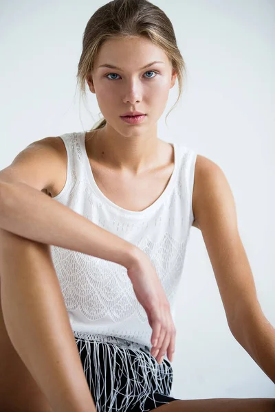 Junge Schöne Frau Mit Gebräunter Haut Sitzt Auf Hellem Boden — Stockfoto