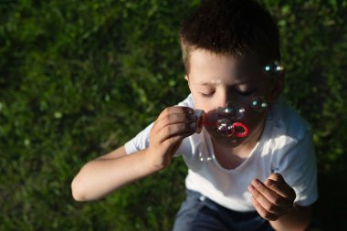 Sabun köpükleriyle bulanık konsept görüntü, sabun köpüğü üfleyen çocuk