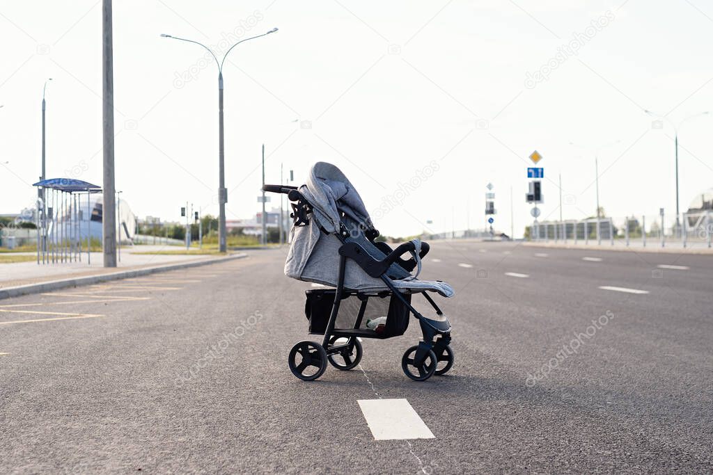 baby stroller is on  road, danger on  roadway, highway threat to life, child safety on road, road traffic concept, there is  stroller with  baby on  roadway