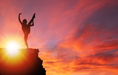 Egzersiz ya da dramatik gündoğumu veya günbatımı arka plan ve kopya alanı uçurumun kenarında germe kız silüeti. Sağlıklı yaşam kavramı.