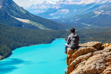 Bir uzun yürüyüşe çıkan kimse yay Peyto Gölü Banff National Park Icefields Parkway üzerinde bakarak Zirvesi kenarında oturuyor. Buzul beslemeli Gölü yaz aylarında için parlak turkuaz renkli suların ünlüdür.