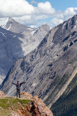 Arka planda Kanada Rocky Dağları ile Icefields Parkway Jasper Milli Parkı'nda Parker Ridge kret kenarında duran genç bir uzun yürüyüşe çıkan kimse.