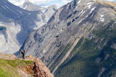 Arka planda Kanada Rocky Dağları ile Icefields Parkway Jasper Milli Parkı'nda Parker Ridge kret kenarında duran genç bir uzun yürüyüşe çıkan kimse.