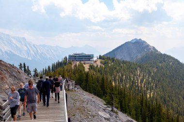 Banff, Kanada - 1 Ağustos 2018: Ziyaretçi ahşap tahta kükürt dağın tepesinde gondol Zirvesi ve panoramik dağ silsilesi içinde Kanada Rocky Dağları, Banff National Park Sanson'ın tepe arasında yürümek.