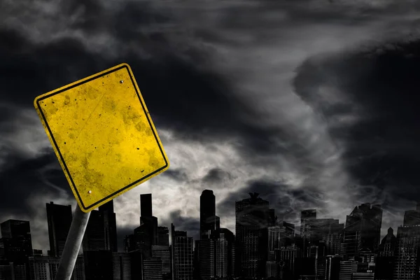 Empty weather warning sign against a powerful stormy background with city silhouette and copy space. Dirty and angled sign with cyclonic winds add to the drama.