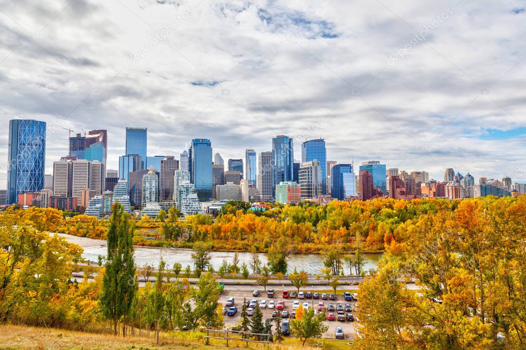 Calgary downtown skyline during Fall or Autumn colors with Bow River surrounding the financial district and its skyscrapers. As viewed from Sunnyside Bank Park at Crescent Heights.