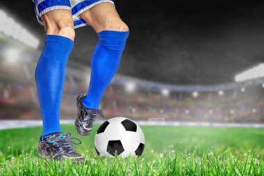 Futbol ile eylem futbolcu parlak açık stadyum yaktı. Ön plan ve futbol topu alan arka plan ve kopya alanı üzerine sığ derinliği ile odaklanmak.
