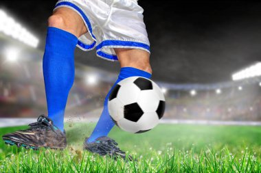 Futbol ile eylem futbolcu parlak açık stadyum yaktı. Ön plan ve futbol topu alan arka plan ve kopya alanı üzerine sığ derinliği ile odaklanmak.