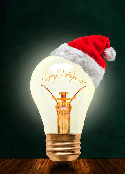 Glowing Light Bulb Wearing Santa Hat Merry Christmas Message Chalkboard — Stock Photo, Image
