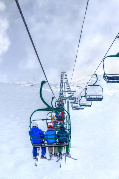 Unidentifiable Skiers Chairlift Going Ski Slope Snowy Mountain Range Canadian — Stock Photo, Image