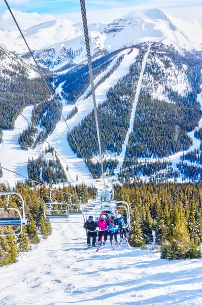 Unidentifiable Skiers Chairlift Going Ski Slope Snowy Mountain Range Canadian — Stock Photo, Image