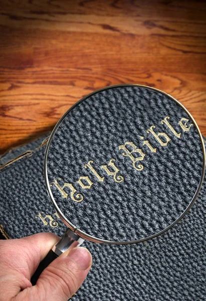 Mão Segurando Lupa Closeup Foco Título Uma Antiga Bíblia Sagrada — Fotografia de Stock