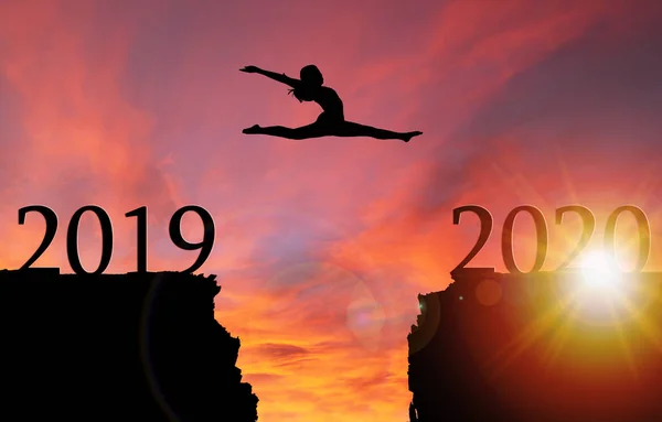 Sunrise silhouet van meisje springen over klif naar Nieuwjaar 2020 — Stockfoto