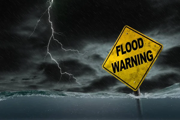 Flood Warning Sign Submerged in Rising Water With Stormy Backgro — Stock Photo, Image