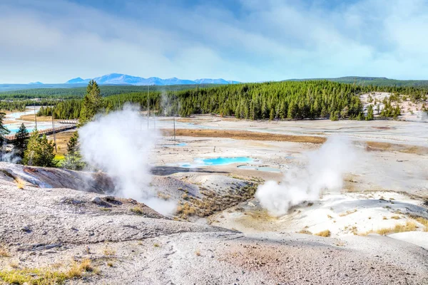 El humo volcánico se eleva desde los terrenos geotérmicos de Porcelana Basin Boardwalk trail en Norris Geyser Basin en el Parque Nacional de Yellowstone, Wyoming, EE.UU. . — Imagen de stock Sendero de Cuenca de Porcelana en la Cuenca Norris Geyser en Yellowstone Nati — Foto de Stock