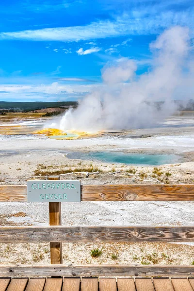 Clepsydra Geyser entra en erupción en el sendero Fountain Paint Pot en la Cuenca del Geyser Inferior del Parque Nacional Yellowstone en Wyoming, Estados Unidos. El géiser salpica constantemente desde varios respiraderos y su vapor se puede ver ampliamente . — Imagen de stock Clepsydra Geyser Entra Erupción Sendero Fountain Paint Pot Cuenca Del — Foto de Stock