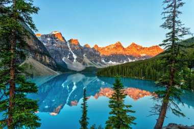 Banff Ulusal Parkı 'nın Kanada Kayalıkları' ndaki Louise Gölü 'nün önünde buzulla beslenmiş turkuaz renkli Moraine Gölü ile On Tepe Vadisi' nin üzerinde altın gün doğumu..