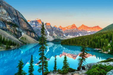 Banff Ulusal Parkı 'nın Kanada Kayalıkları' ndaki Louise Gölü 'nün önünde buzulla beslenmiş turkuaz renkli Moraine Gölü ile On Tepe Vadisi' nin üzerinde altın gün doğumu..