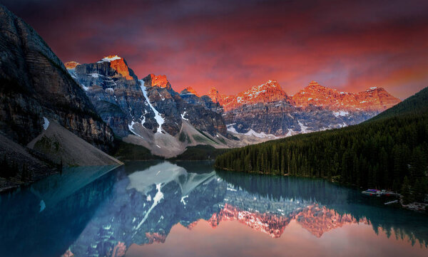 First light of dawn at Moraine Lake with golden sunrise over the Valley of the Ten Peaks in the Canadian Rockies of Banff National Park.