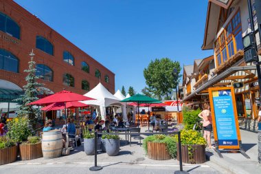 BANFF, CANADA - 29 Temmuz 2020: Turistler Banff Ulusal Parkı 'ndaki Banff Bulvarı' nda yemek yiyorlar. Sokak, ziyaretçiler arasında daha fazla sosyal mesafeye izin verilmesi için COVID-19 nedeniyle kapatıldı.