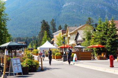 BANFF, CANADA - 29 Temmuz 2020: Banff Ulusal Parkı 'ndaki Banff Bulvarı boyunca yürüyen turistler. Sokak, ziyaretçiler arasında daha fazla sosyal mesafeye izin verilmesi için COVID-19 nedeniyle kapatıldı.