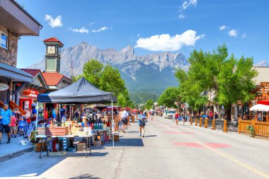 Canmore, Kanada - 30 Temmuz 2020: Kanada Kayalıkları 'nda Canmore şehir merkezinde popüler turistler yürüyor. Yol, ziyaretçiler arasında daha fazla sosyal mesafeye olanak sağlamak amacıyla COVID-19 nedeniyle trafiğe kapatıldı.