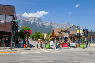 Canmore, Kanada - 30 Temmuz 2020: Kanada Kayalıkları 'nda Canmore şehir merkezinde popüler turistler yürüyor. Yol, ziyaretçiler arasında daha fazla sosyal mesafeye olanak sağlamak amacıyla COVID-19 nedeniyle trafiğe kapatıldı.