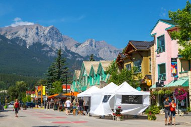 Canmore, Kanada - 30 Temmuz 2020: Kanada Kayalıkları 'nda Canmore şehir merkezinde gezen ve yemek yiyen turistler. Yol, ziyaretçiler arasında daha fazla sosyal mesafeye olanak sağlamak amacıyla COVID-19 nedeniyle trafiğe kapatıldı.