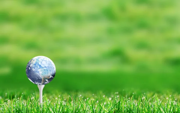 Planet earth golf ball on tee and with defocused bokeh golf course green background and copy space.  Concept of eco-friendly golf course. Elements of this image used with permission from NASA imagery https://visibleearth.nasa.gov/images/57723/the-blu