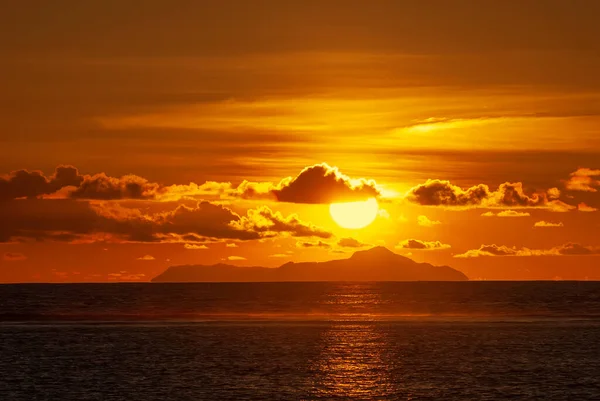 Seyşeller Takımadası 'nın Praslin adası üzerinde bulutlu gökyüzü ile renkli gün batımı